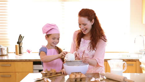 madre y hija sonrientes cocinando juntas