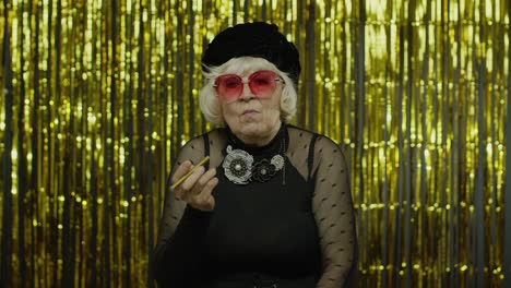 Mujer-Madura-De-Estilo-Anciano-Vestida-De-Moda-Con-Gafas-De-Sol-Posando,-Fumando-Cigarrillo-Electrónico