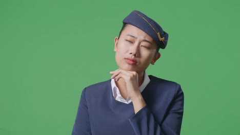 close up of asian woman air hostess thinking about something and looking around while standing in the green screen background studio