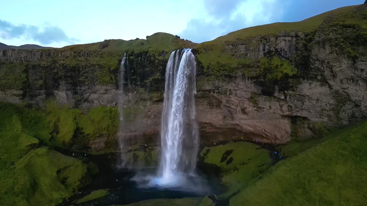 4K aerial panorama of Seljalandsfoss, displaying the powerful waterfall, meandering river, and vast open fields, an iconic view of Iceland’s rugged natural beauty. Iceland_23