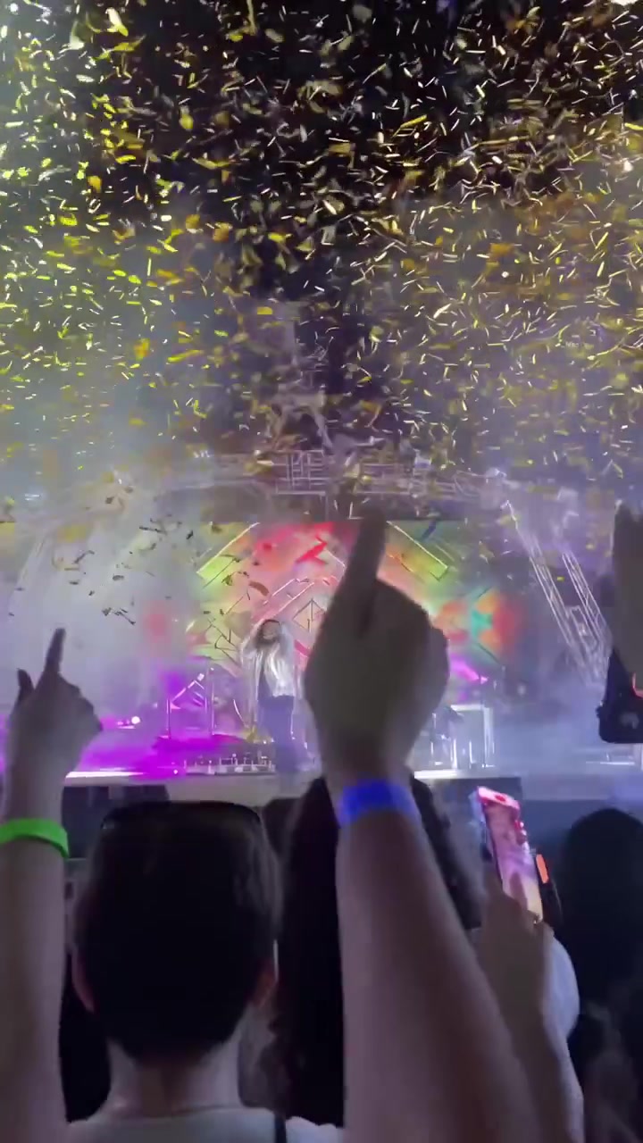 Cantante che si esibisce sul palco con coriandoli che cadono durante un concerto