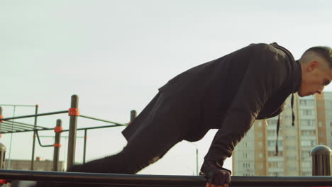 athlete doing straddle planche on bars outdoor