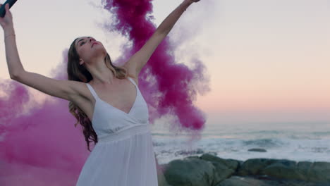 Mujer-Sosteniendo-Una-Bomba-De-Humo-Rosa-Bailando-En-La-Playa-Temprano-En-La-Mañana-Celebrando-La-Libertad-Creativa