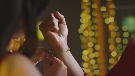 sister ties rakhi on brother during raksha bandhan with a hug, real time