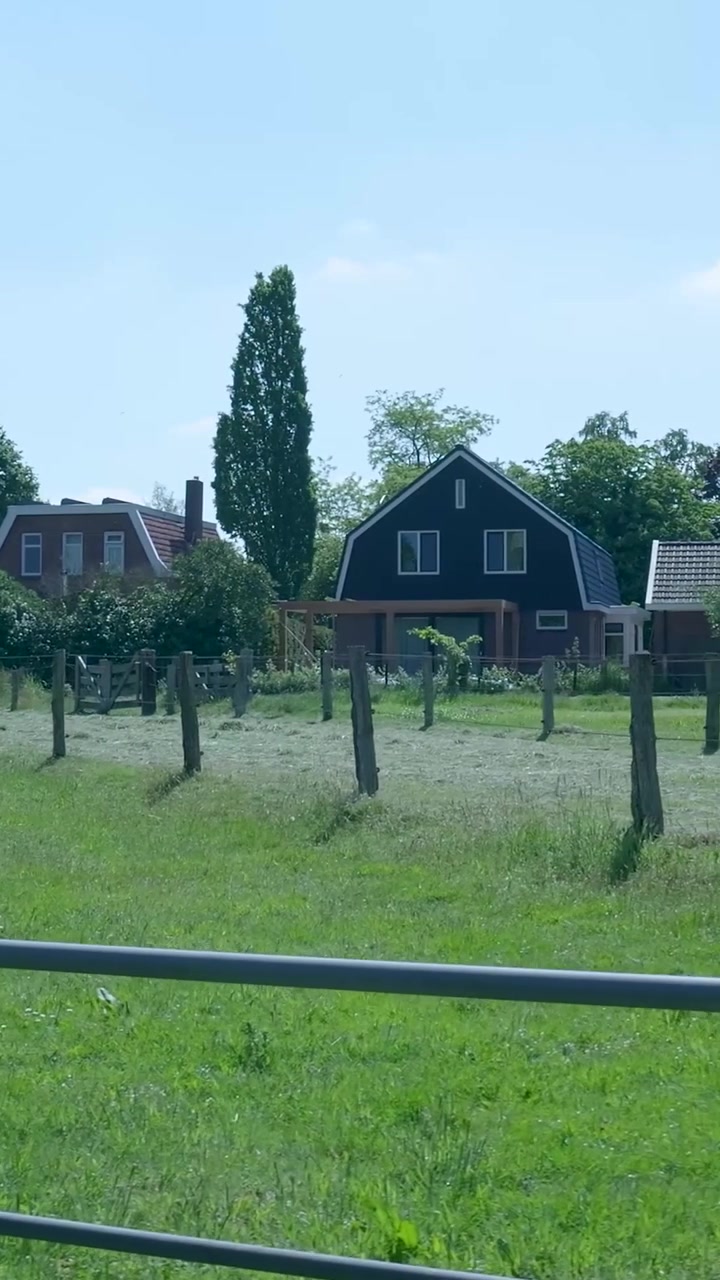 Ländliche Landschaft mit Bauernhaus und grüner Weide
