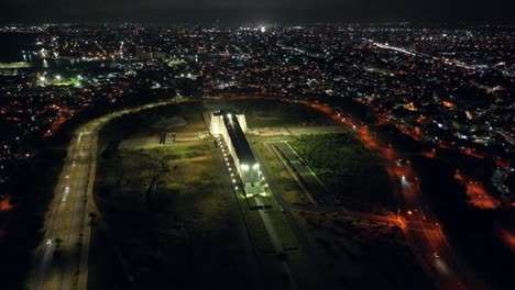 조명된 콜럼버스 등대 (columbus lighthouse) 의 파노라마 뷰를 가진 야간 항공기