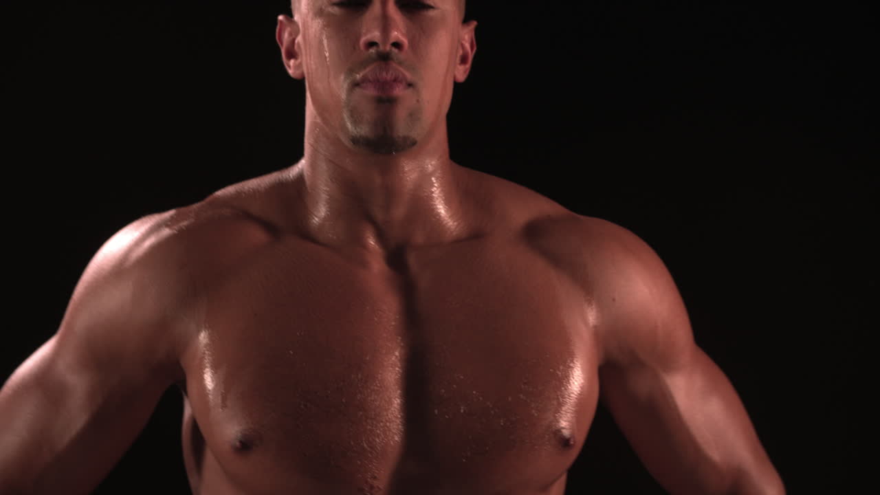 culturista de pecho desnudo con las manos en las caderas