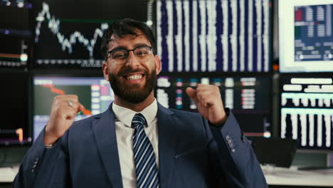 excited businessman celebrating success in front of stock market charts