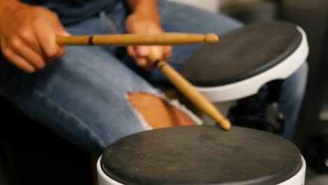 young male practicing on drum pads in slow motion