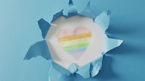 video of rainbow heart over ripped blue background