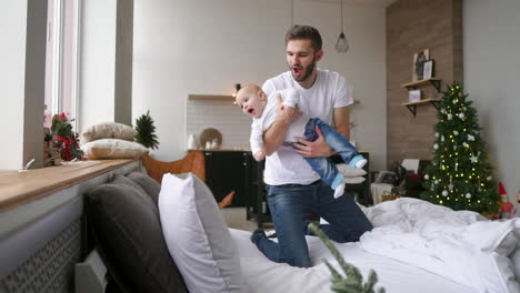 dad and his cute and lovely boy playing joyfully in a bright room