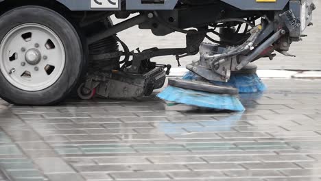 street cleaning machine in action on cobblestone street