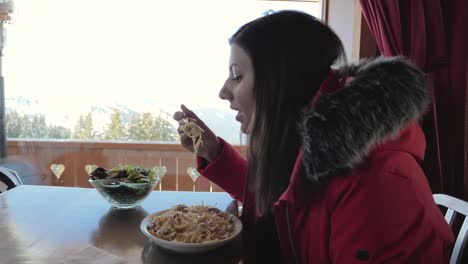 skier eats spaghetti at a cafe in the mountains in winter