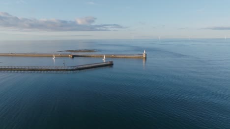 drone clip showing two sailboats in north sea harbour and calm blue sea