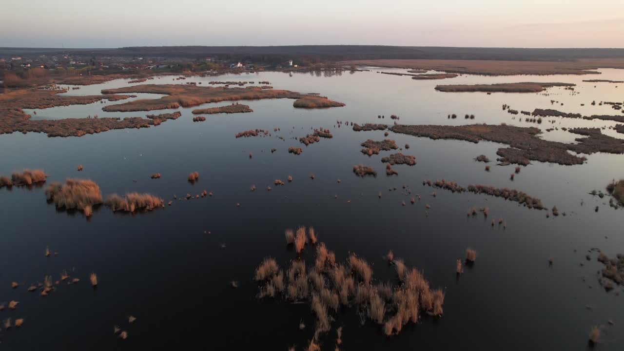 vista aérea panorámica del delta de neajlov en comana durante la puesta de sol con agua serena y vegetación exuberante