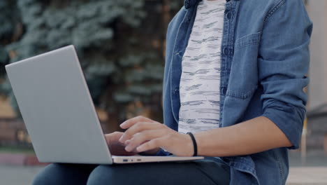 teenager working on a laptop outdoors
