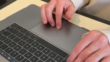 primer plano de las manos adultas caucásicas escribiendo en un teclado portátil macbook pro