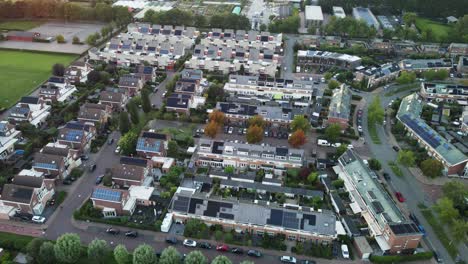 high angle of a green suburban neighborhood with solar panels on top of the homes