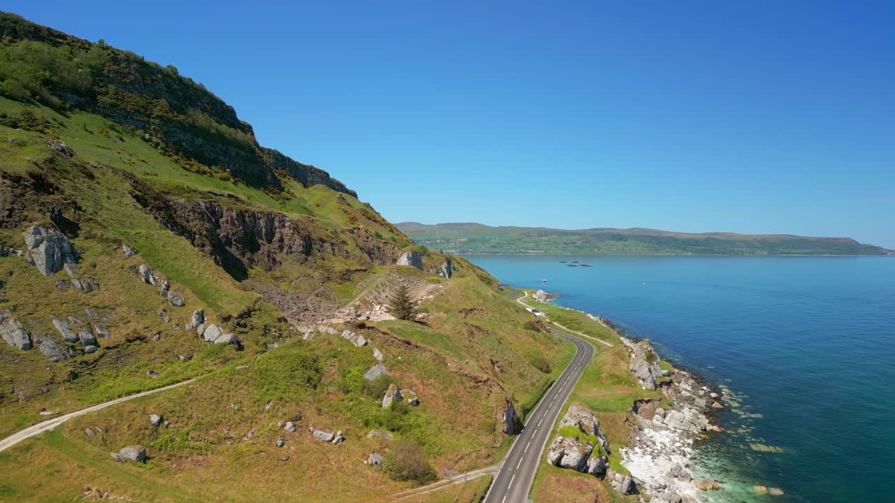 Rising aerial video of the Causeway Coastal Route at Glenarm in County Antrim, Northern Ireland, UK on a bright and sunny day. Filmed in 4K, 60FPS and with Rec709 color.