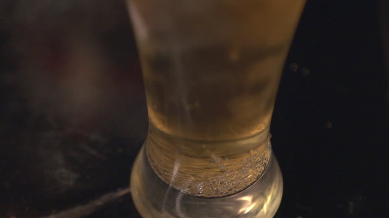 Small Golden Bubbles Rising On The Glass Of Cold Beer. - close up shot