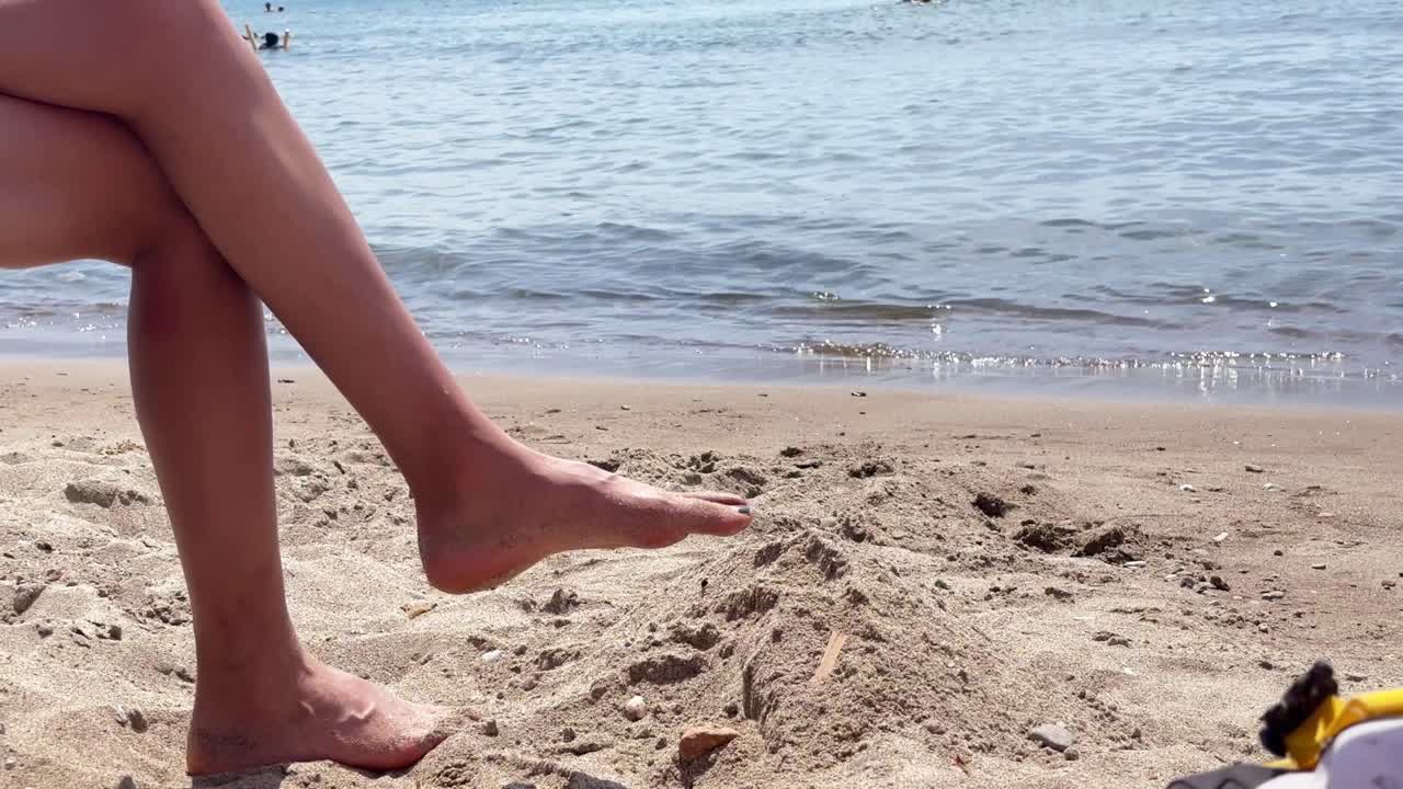 -4K resolution 3840x2160 video -Close-Up shot from sea side. A girl relaxing on the sea side. Chill time in the beach
