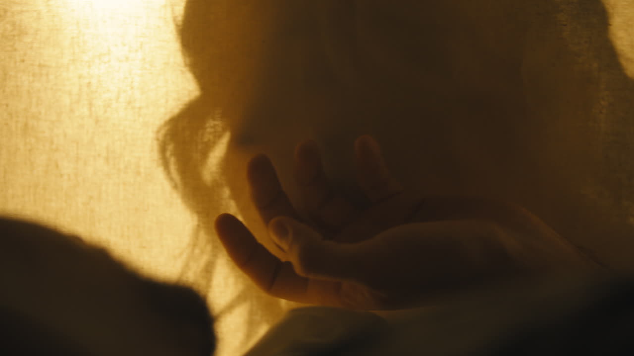 남자가 다른 쪽에 낳는 동안 모슬린에 여자 백라이트의 실루엣