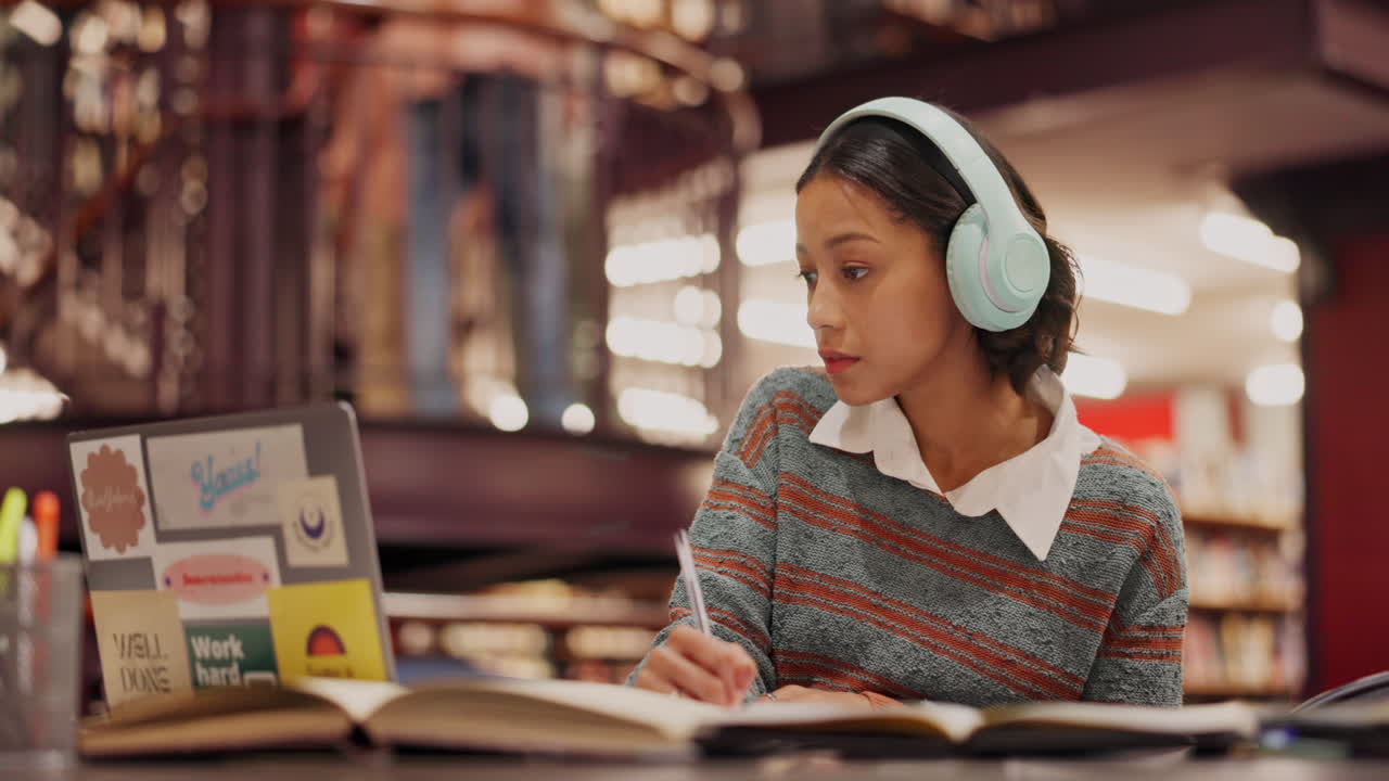 estudiante estudiando en la biblioteca con auriculares