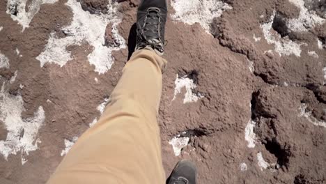 hiker feet first person view walking on salt desert in atacama region