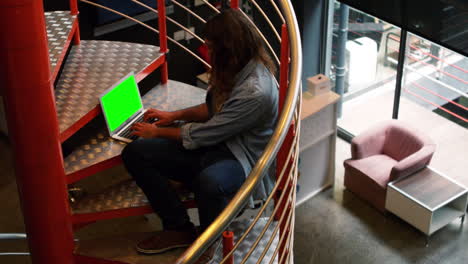 ejecutivo sentado en las escaleras y trabajando en la computadora portátil