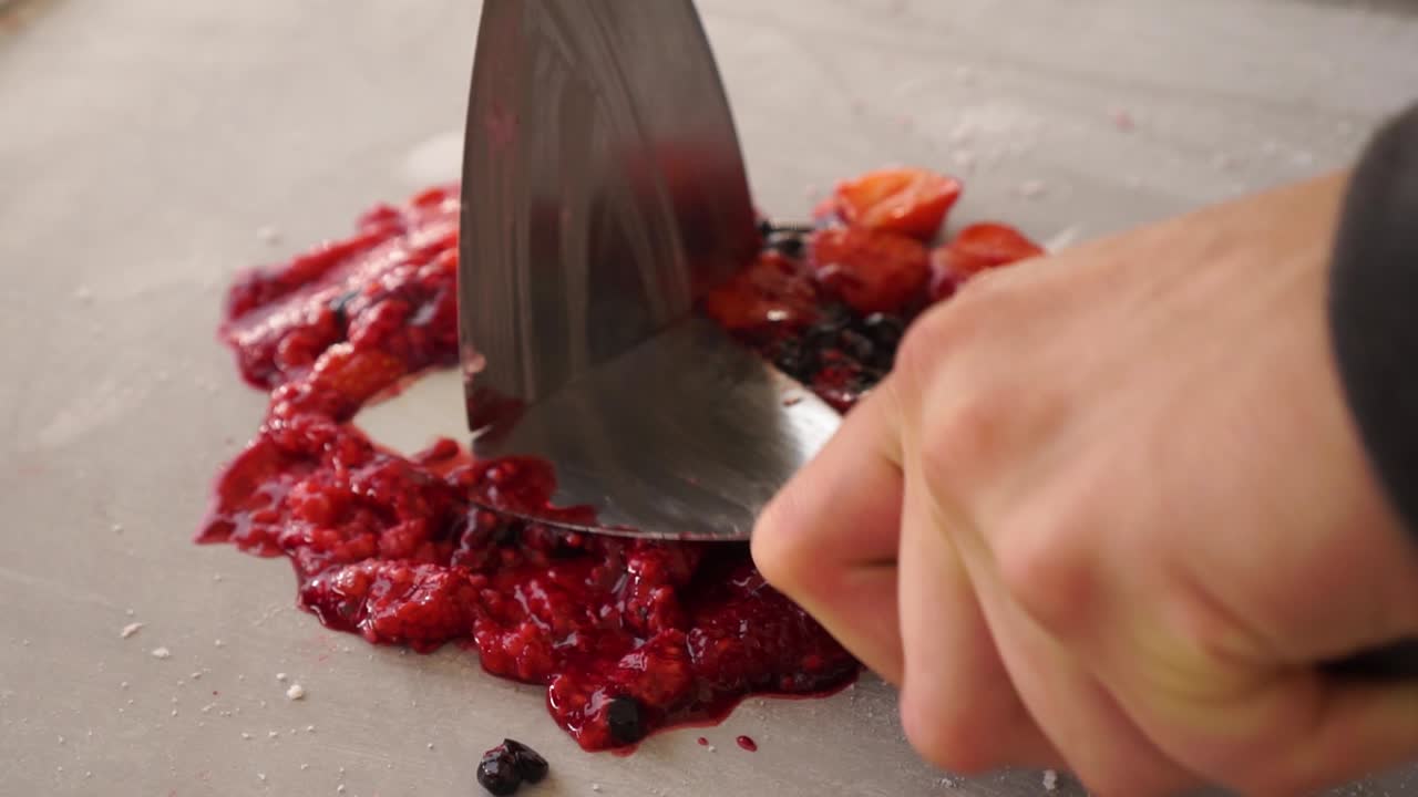 slowmo - preparación de dulce hecho a mano de fresa, arándano, mora, postre de helado enrollado frito al estilo tailandés en el festival de comida