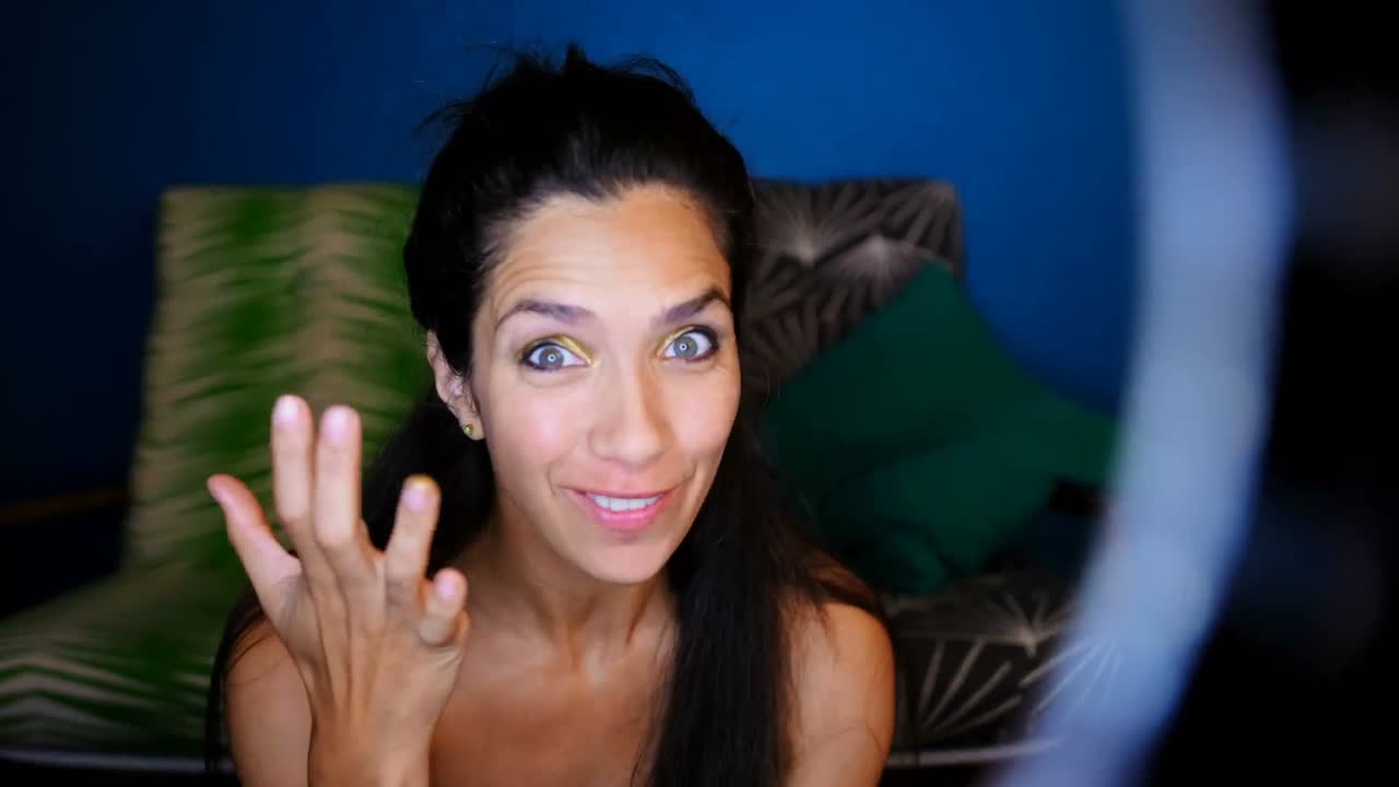 Female video blogger applying eyeshdow by hand 4k