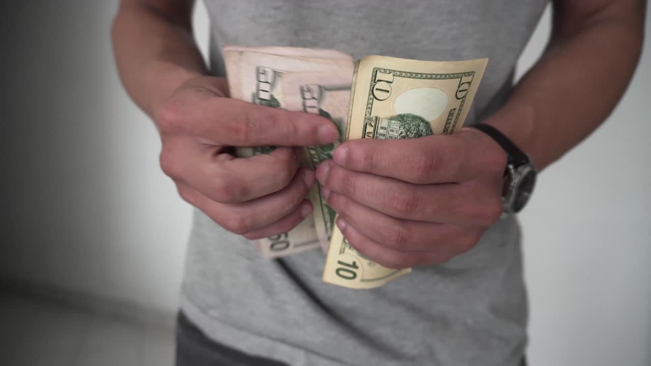 hombre contando dolares para pagar