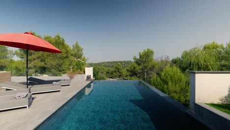 slow-rising shot of a swimming pool with sunloungers at a villa in st gely du fresc