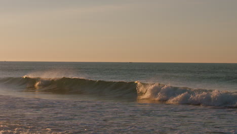 small waves breaking during a calm sunrise in luz, portugal