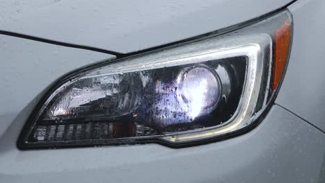 A-short-video-of-a-car's-headlight-turning-on-while-covered-in-rain-droplets