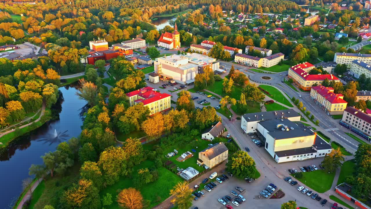 Bright sunset over Valmiera city center with river, park, and St, Simon's church