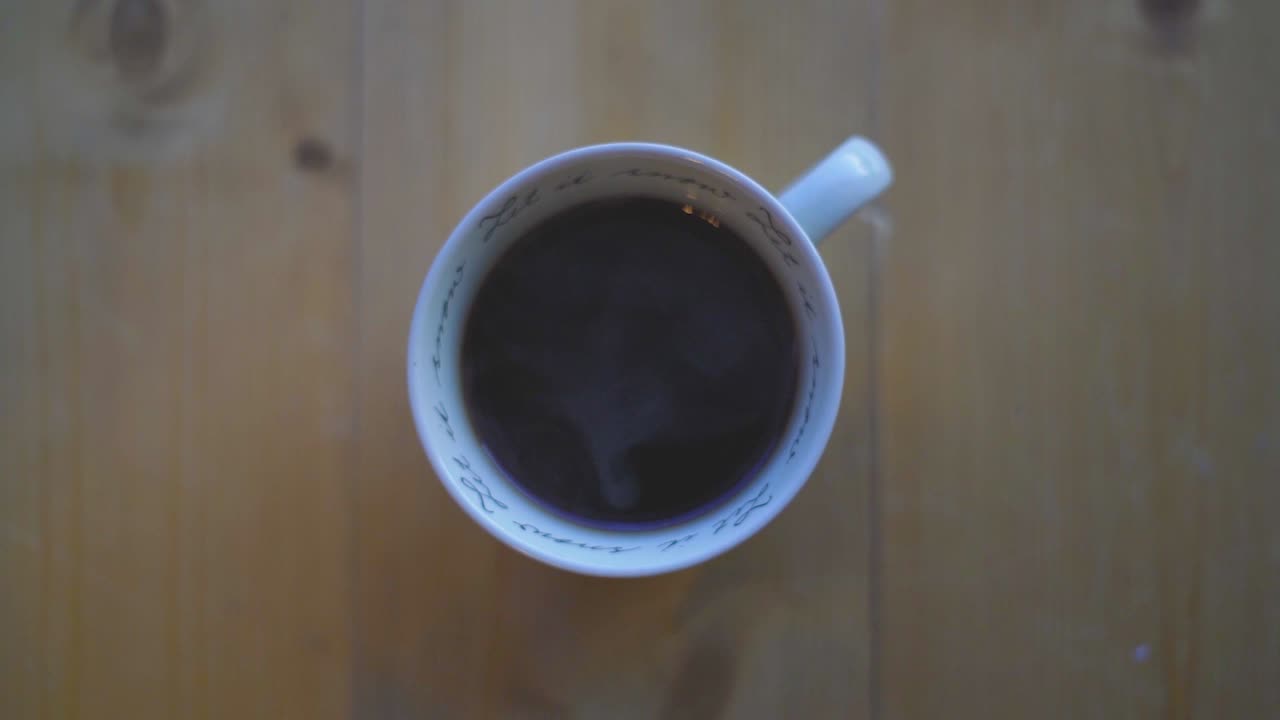 Hot black coffee in a white cup on a table. Tasty coffee. Caffeine.