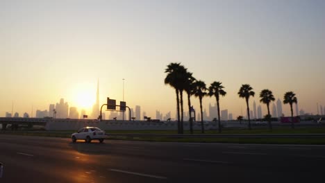 dubai skyline at sunset seen from a driving car with the city skyline backlit