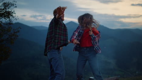 camping lovers express joy on mountains evening. active couple dance on nature.