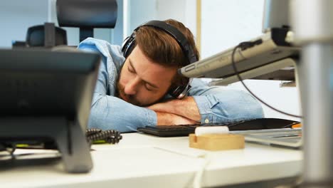 Male-graphic-designer-sleeping-at-desk