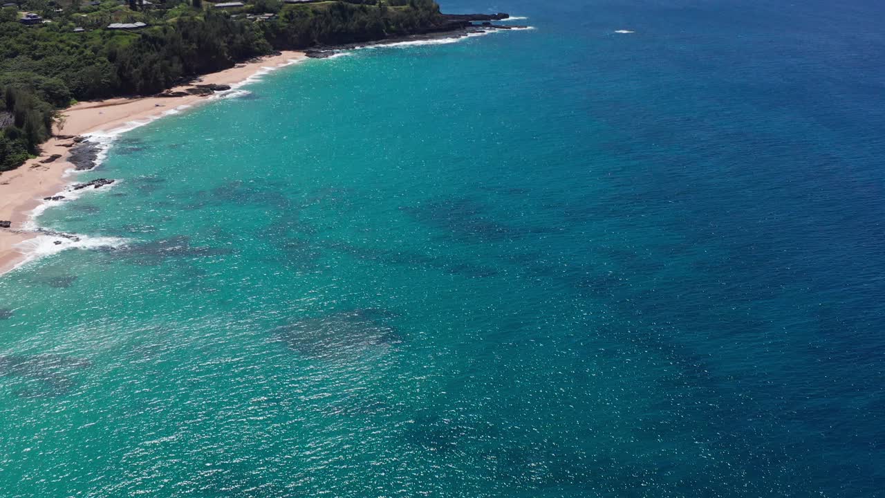 Aerial wide tilting up shot of the picturesque North Shore coastline near Princeville in Kaua'i, Hawai'i