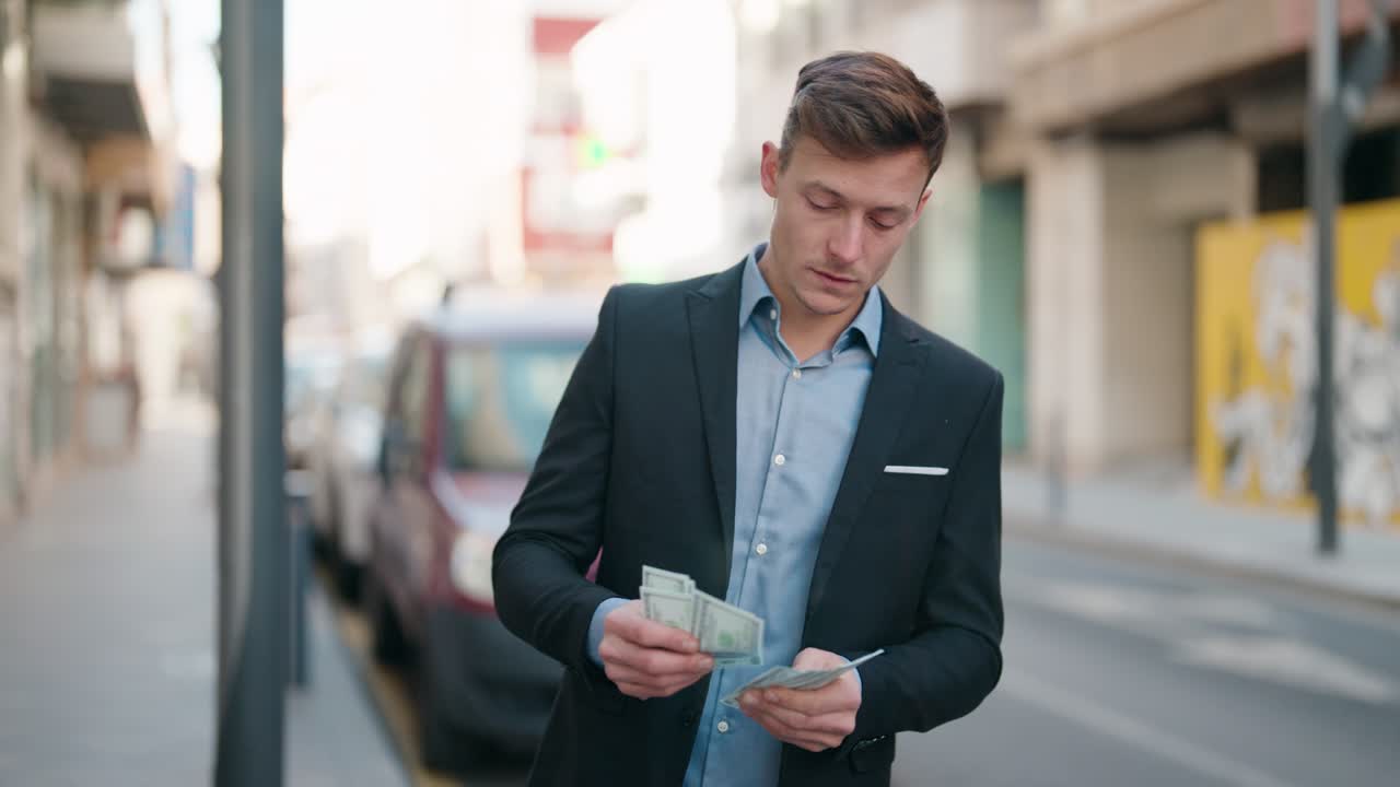 거리에서 달러를 세는 심각한 표정을 가진 젊은 백인 남자