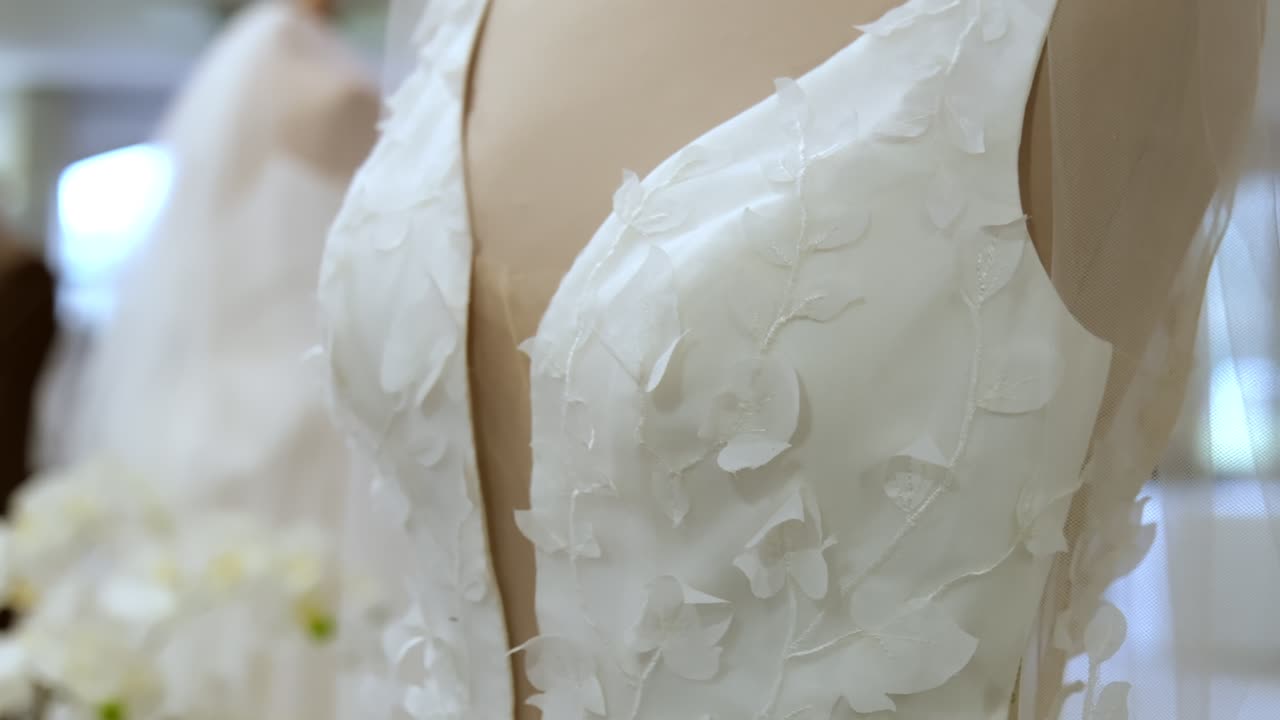 Close up of wedding dresses on mannequins at wedding event.