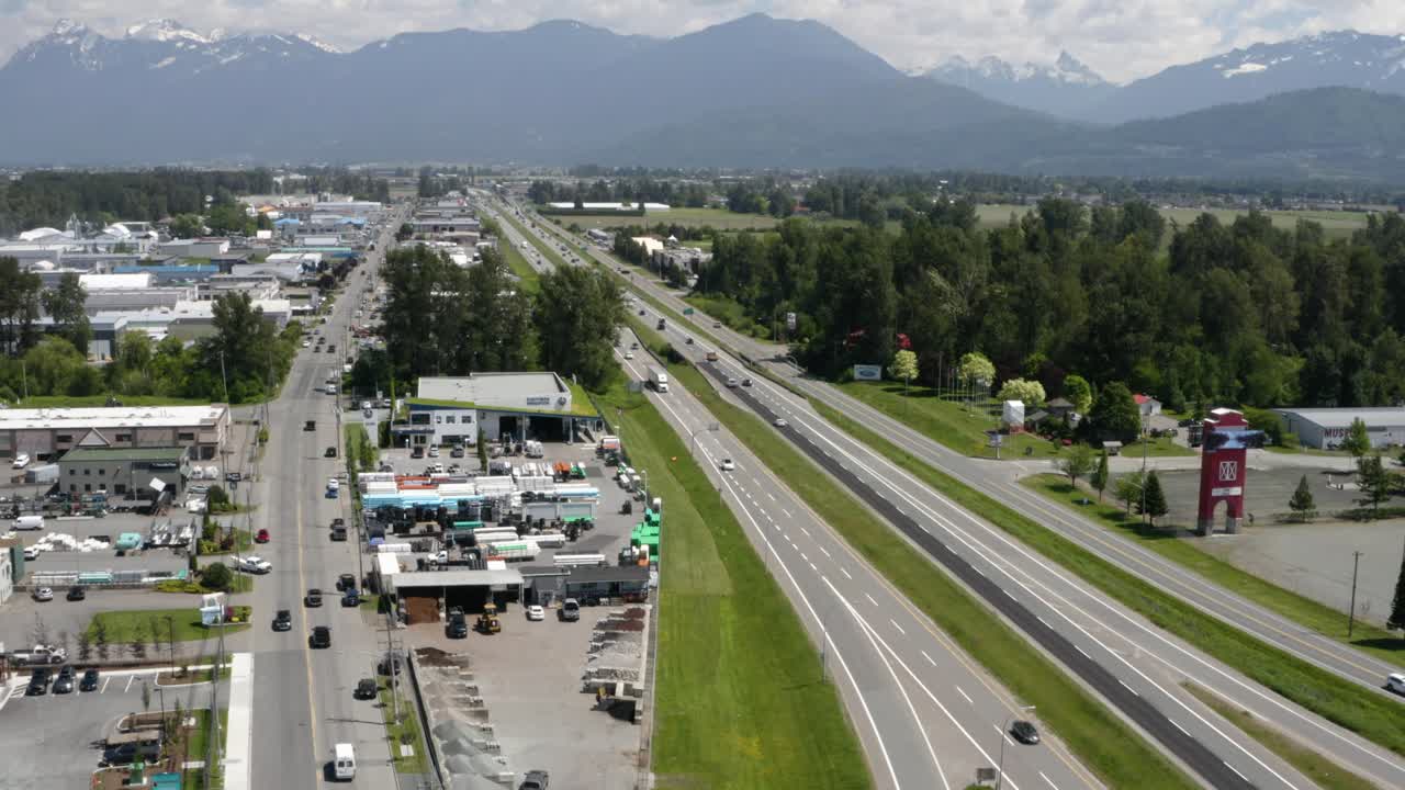 산업 지역을 통과하는 고속도로에서 공중 샷을 뒤로 당기십시오.