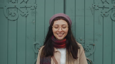 Portrait-of-Cheerful-Woman-Posing-against-Old-Gates