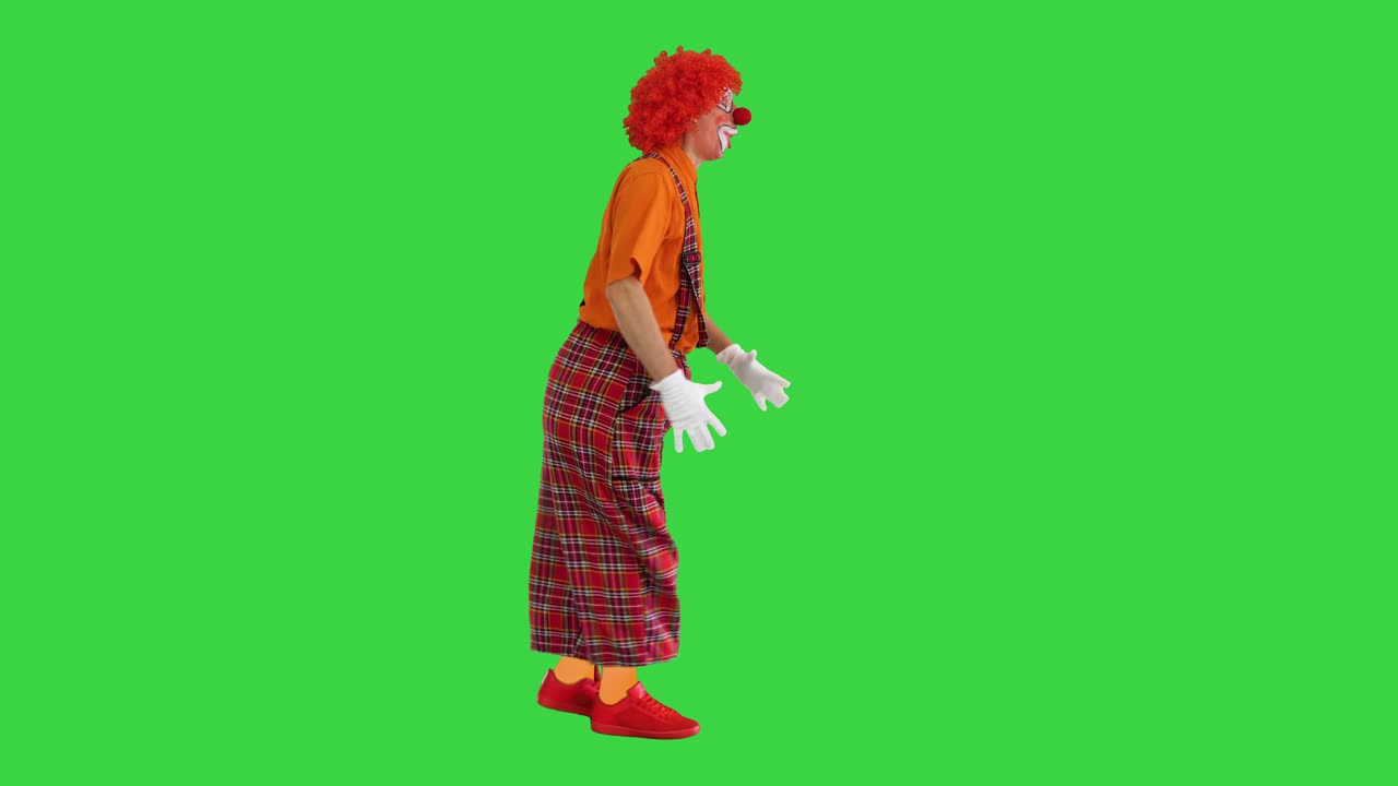 Sjov klovn går og kigger sig tilbage indimellem på en grøn skærm, Chroma Key