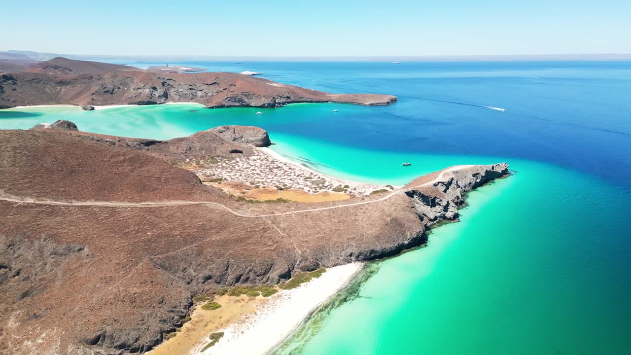 Turquoise water and scenic hills surround a quiet beach at Tecolotito, La Paz