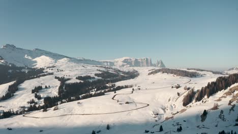 Dolly-forward-drone-shot-towards-mountain-road-in-seiser-alm-Italian-dolomites