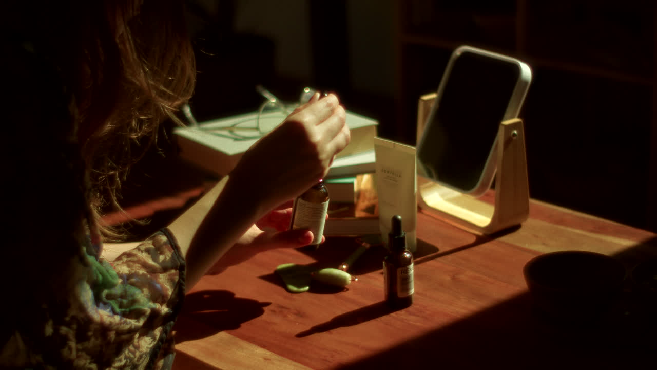 Woman Applying Skincare Products at a Table