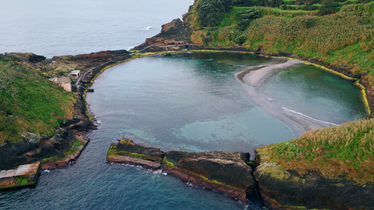 Drone view island lagoon zoom out. Breathtaking rocky volcanic cape in summer.